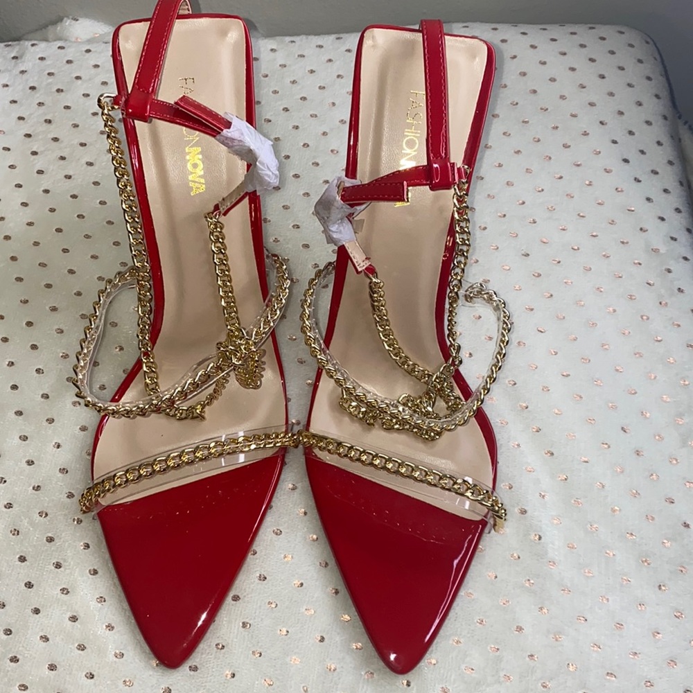 Red heel with gold chain around ankle. Has a clear heel. Not for wide feet